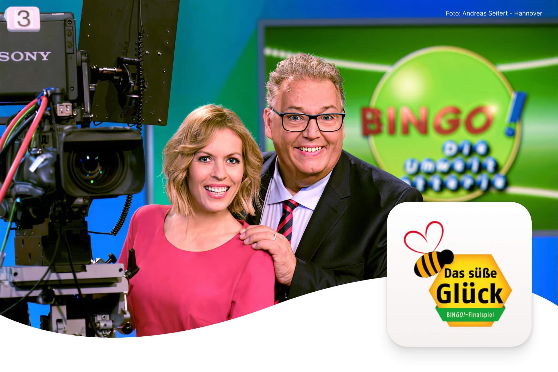 Zwei lächelnde Moderatoren, Michael Thürnau und Jule Gölsdorf, im TV-Studio der Sendung „BINGO! – Die Umweltlotterie“, vor einem Hintergrund mit der Aufschrift ‚Bingo‘ und dem Finalspiel-Logo „Das süße Glück“ mit Bienenmotiv.